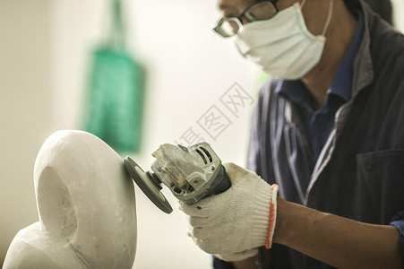 雕刻人物专注的石匠师傅在打磨石雕背景