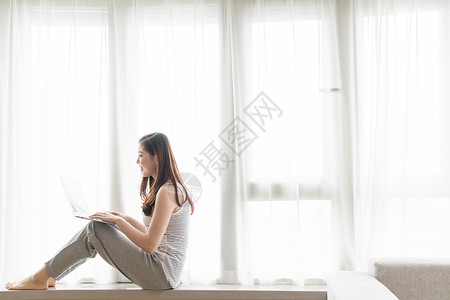 好剧坐在窗台使用电脑休闲放松的女性背景