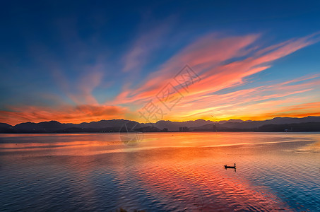 颁奖剪影洱海清晨的彩霞倒映水中背景