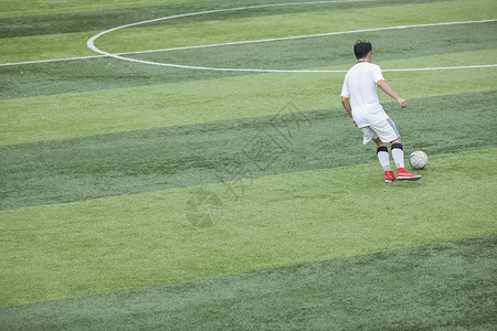 最佳射手足球运动员在草坪上训练踢球背景