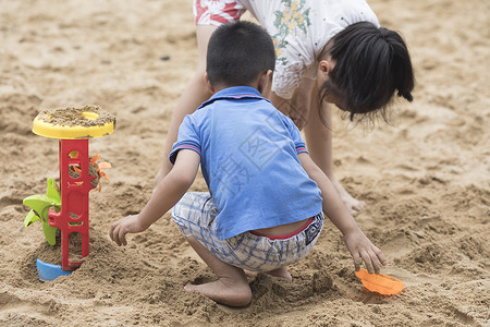 结伴小朋友在沙滩上玩耍背景