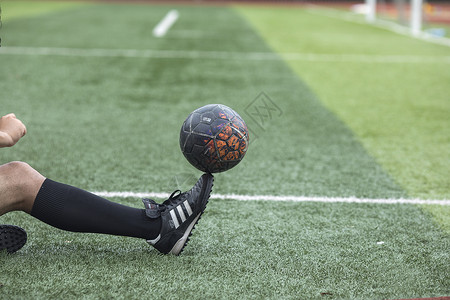足球运动员在草坪上训练踢球高清图片