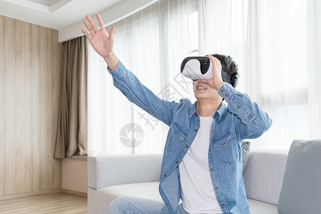 vr触摸在客厅头戴vr眼镜体验虚拟现实的男士男人背景