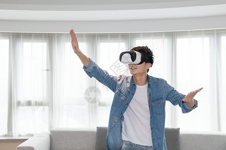 在客厅头戴vr眼镜体验虚拟现实的男士男人背景图片