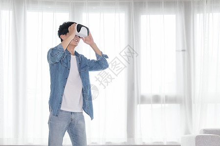 感受科技在客厅头戴vr眼镜体验虚拟现实的男士男人背景