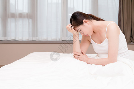 家庭主妇累了年轻女性失眠头痛坐在床上背景