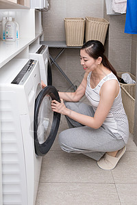使用洗衣机洗衣服的家庭女性高清图片