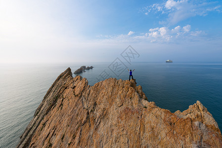 游艇上的人站在海边礁石上的人物背影背景