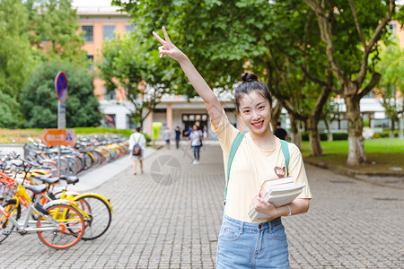 大学校园内女生抱着书本背景