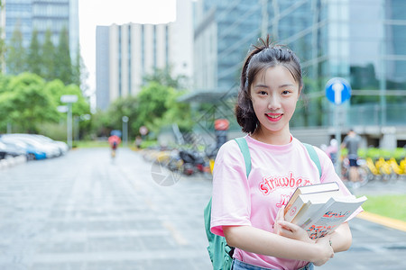 街上美女大学校园内女生抱着书本背景