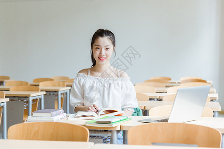 电脑桌椅大学教室女生看书学习背景