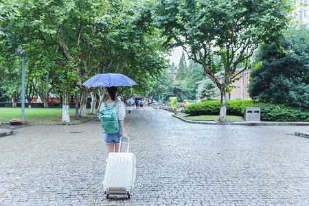 水上拖伞下雨天女生拉旅行箱背影背景