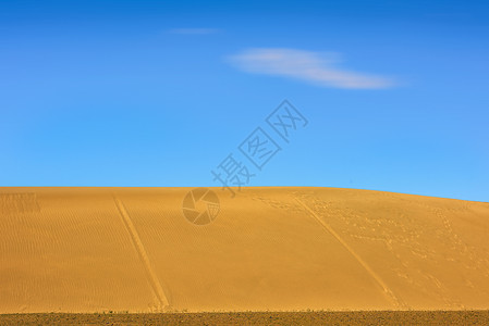蓝天白云下的沙丘背景图片