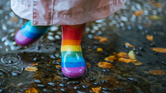 下雨天爸爸穿雨衣接女儿下雨天穿雨鞋的小朋友玩水背景