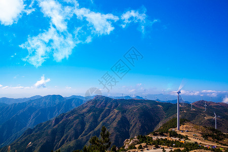 巍峨的山山峰之巅的风车背景