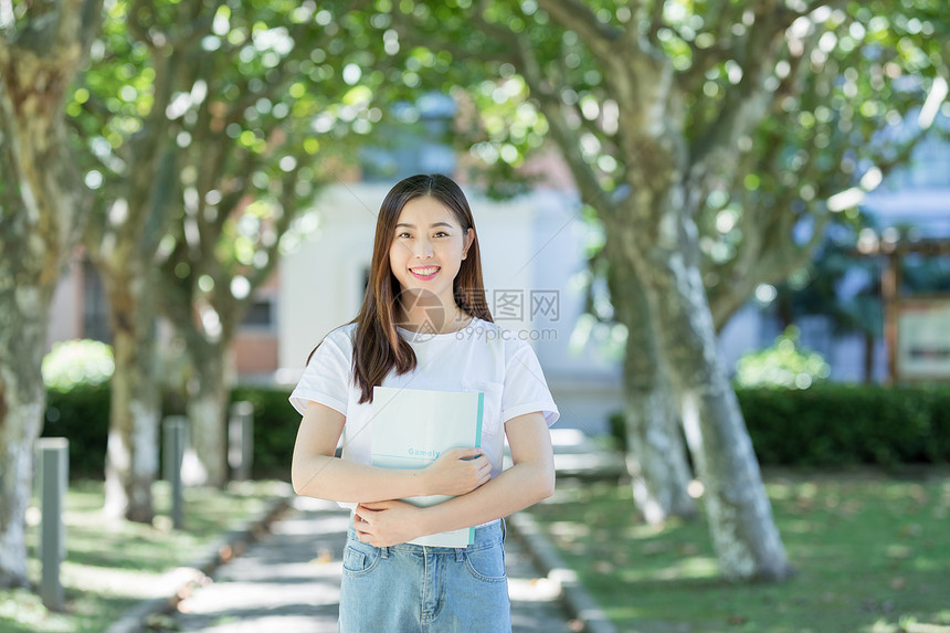 走在校园林荫道下的甜美女生图片