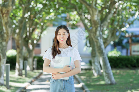 走在校园林荫道下的甜美女生高清图片