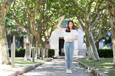 再见老同学校园里拿着书微笑打招呼的女生背景