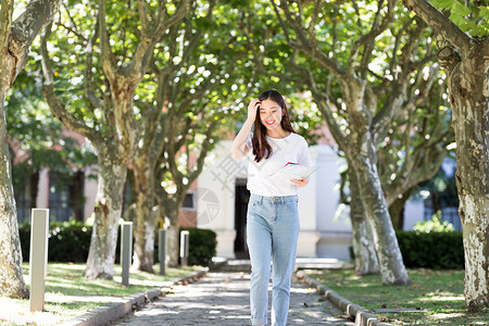 学校里抱着书边走路边撩头发的女同学高清图片