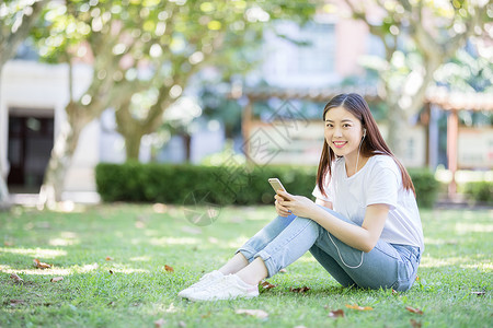 坐在校园草坪上玩手机的女生图片