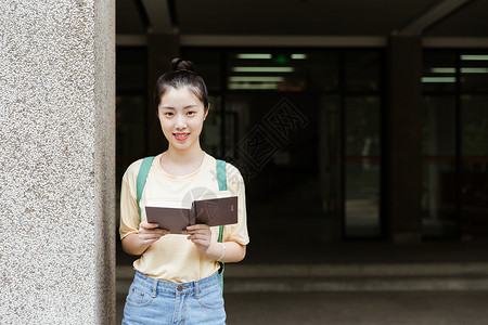 大学教学楼前女生在看书图片