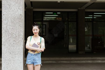 大学教学楼前女生在看书图片