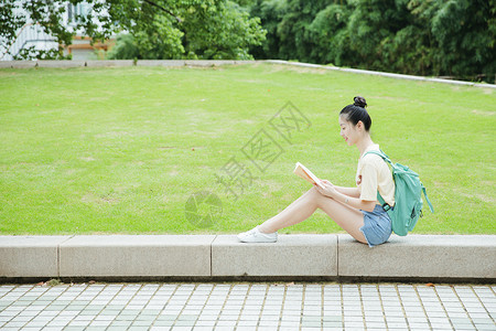 校园草地前女生在看书图片