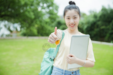 校园草地前女生举大拇指图片