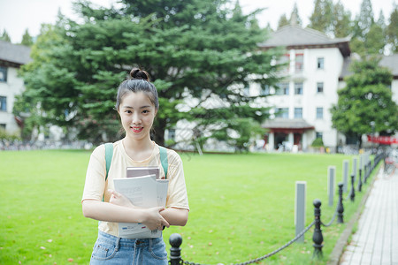 校花校草校园里抱着书本的女生背景