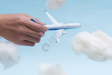 手在空中飞机在云中背景