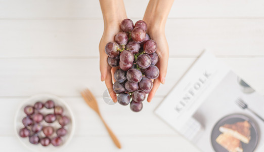 捧葡萄的手淡雅健康美食高清图片