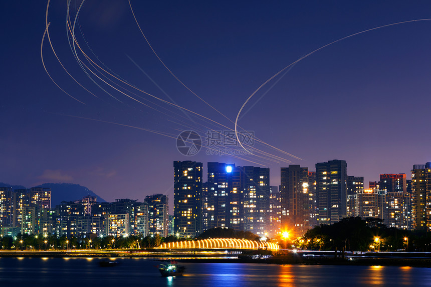 城市夜空上的飞机航道灯轨图片