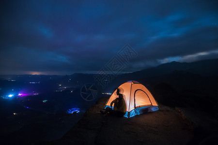 坐在山顶夜晚星空帐篷露营背景