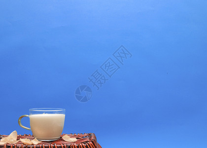 一杯牛奶放在竹篮上高清图片