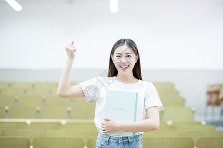 女同学演讲抱着书自信的站在教室里的大学生背景