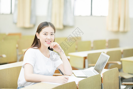 毕业季女同学教室里使用笔记本电脑学习的学生背景
