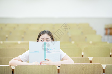 教室里用书挡着脸的可爱女生图片