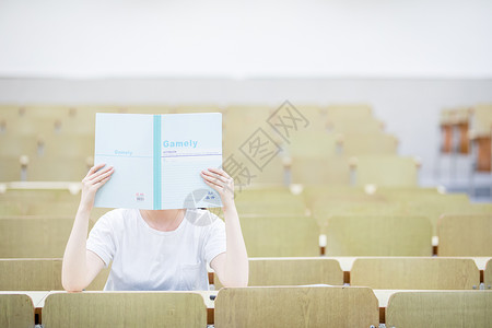 教室里用书挡着脸的可爱女生高清图片