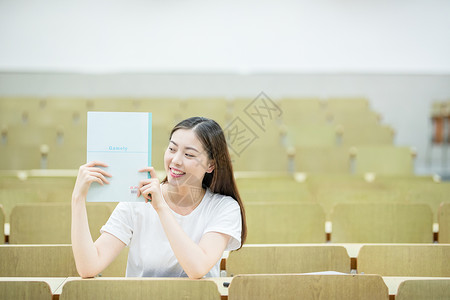 教室里用书挡着脸的可爱女生高清图片