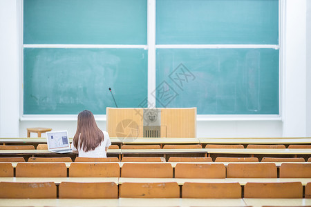 空旷的教室里正在学习的女生背影背景图片