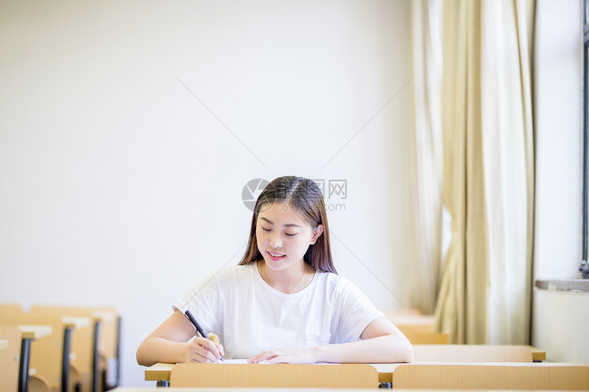 教室里自习学习写字的女大学生图片