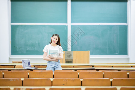 坐在黑板前学习的女学生背景图片