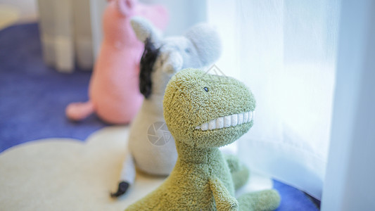 毛绒恐龙坐在窗台的可爱玩偶背景