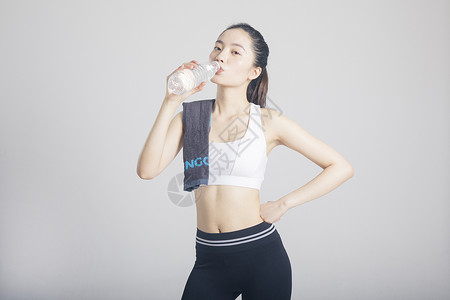 擦汗喝水的运动女性棚拍高清图片