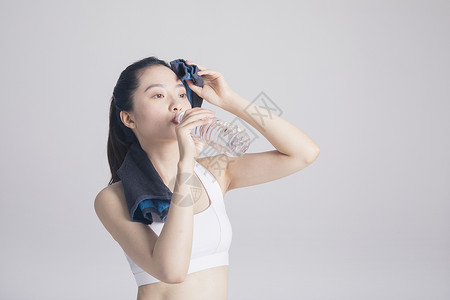 擦汗喝水的运动女性棚拍高清图片