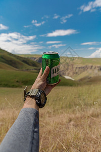 手拿啤酒看风景图片