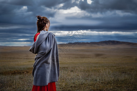 红衣服草原上凝望天空的女孩背景
