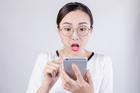 中国表演职业女性看手机惊讶棚拍背景