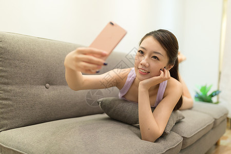 手机微信聊天躺在沙发上自拍的女生背景