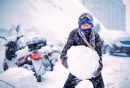 孩子玩雪雪中堆雪球玩雪的男孩背景